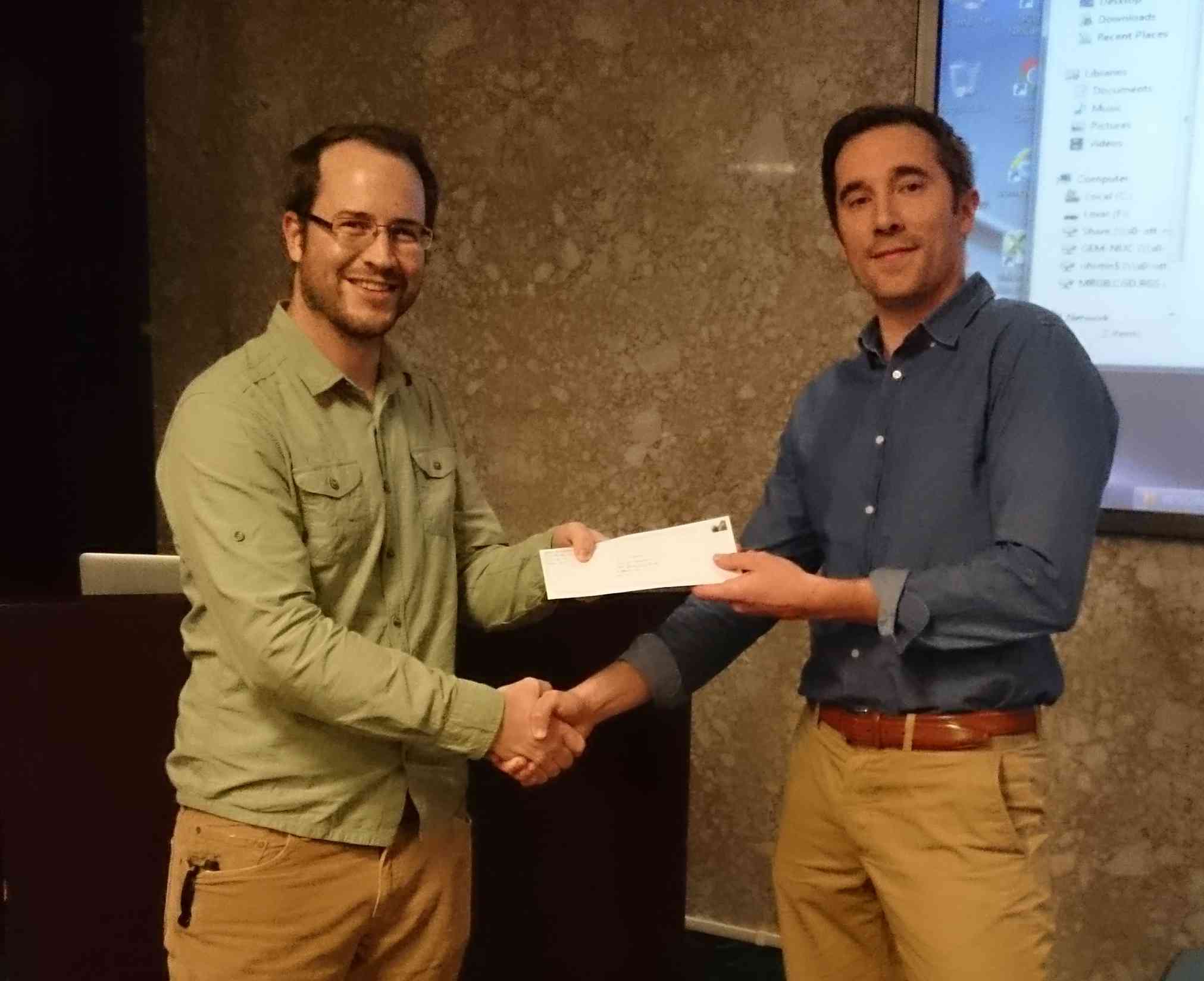 Michael Cunningham (MSc, Carleton) receiving renewal of CGG scholarship from Adam Shales, CGG, at KEGS-Ottawa meeting